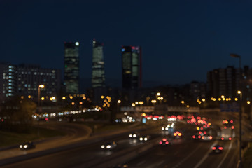 Fototapeta na wymiar Bokeh de las luces de Madrid de noche con las cuatro torres de fondo.