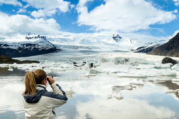 Woman observes movements and sounds of the glacier
