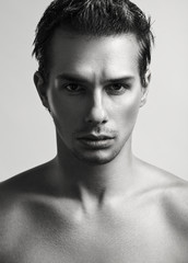 Closeup black and white studio fashion portrait of young handsome man.