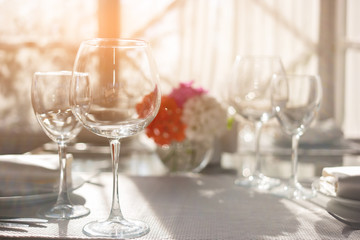 Empty wineglasses on white tablecloth. Glasses and sunshine. Invite friends for lunch. The perfect cleanliness.