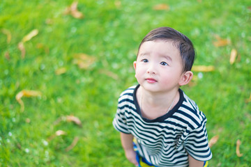 Close-up little Asian boy looking up somewhere and thinking with