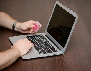 Male hands with laptop and credit card when paying online, Shall
