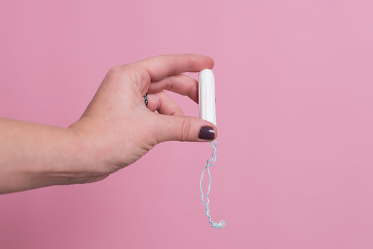 Woman's hand holding a clean cotton tampon