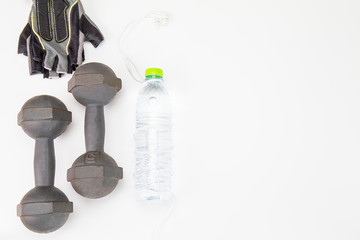 Old dumbbell, fitness grove and plastic water bottle and in ear headphone on white background, sport exercise concept