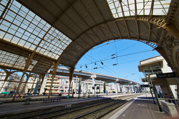France, Nice, 15 august 2016: Panorama of the railway station in the center, sunny day, blue sky, a lot of tourists, Rails  under glass a roof, in front of shaped visor, sncf, gare