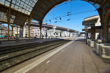 France, Nice, 15 august 2016: Panorama of the railway station in the center, sunny day, blue sky, a lot of tourists, Rails  under glass a roof, in front of shaped visor, sncf, gare