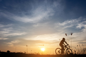 silhouette of bicycle rider at sunset