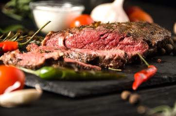 rare steak black square plate spices rosemary