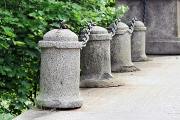 historic concrete pillars with metal chains as a guard at the road bridge. - obrazy, fototapety, plakaty