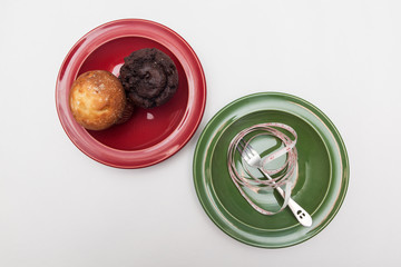 delicious donut and muffin, fork and tape-measure on plate, on white backgrounds, diet concept