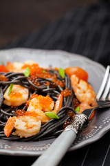 Black spaghetti with shrimps and red caviar