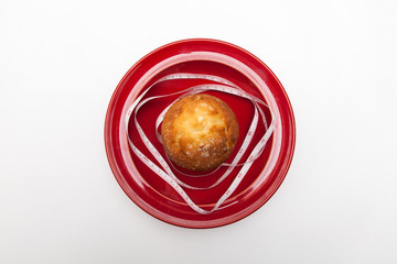 delicious donut and muffins with tape-measure on plate, on white backgrounds, diet concept