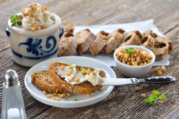 Deftiges Griebenschmalz im Schmalztopf mit rustikalem Brot serviert - Hearty lard with greaves and...