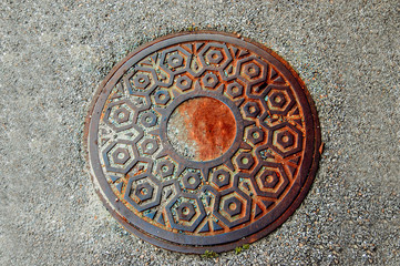 Manhole closed in the street above view.