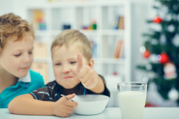 Adorable little blond kids eating cereals for breakfast or lunch. Healthy eating for children. At nursery or at home.