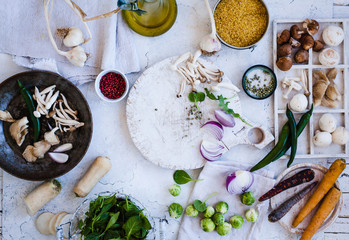 Vegetarian and dieting Cooking ingredients. Edible mushrooms varieties in cast iron pan with bulgur and mix vegetables.