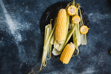 Fresh corn on cobs on rustic blue table, copy space, overhead of corn on the cob.  © casanisa
