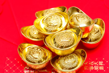 Stack of Chinese Gold Ingots on red Background.
