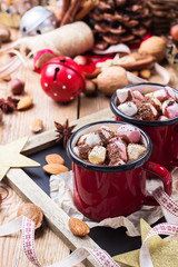 Hot chocolate with marshmallows and spices on christmas table
