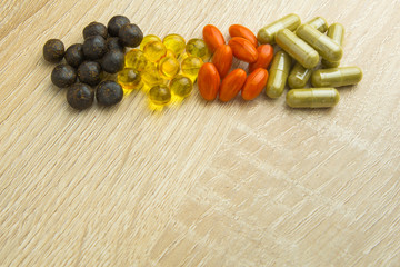 Herbal pills with healthy medical plant. Green leaf, alternative drug on wood ground
