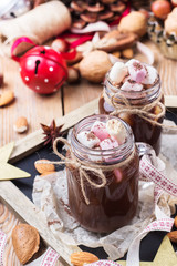 Hot chocolate with marshmallows and spices on christmas table