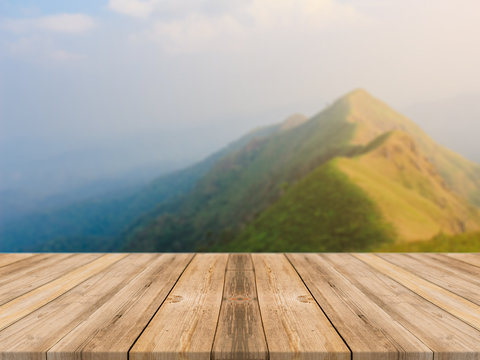 Wooden board empty table in front of blurred background. Perspective brown wood table over blur sunset mountain landscape background - can be used mock up for display or montage your products.