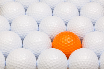 White and orange golf balls in the box