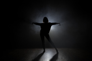 Fototapeta na wymiar Dancer in studio with smooke on a dark background