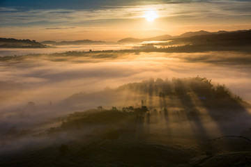 mist over the valley of mountain at sun rising giving a beautiful colour in the field