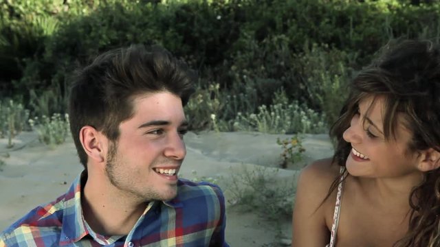 Young couple sitting on sand