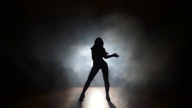 Sexy dancer in a smoke on a black background