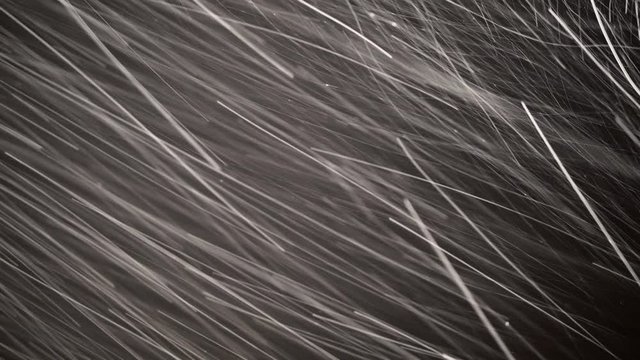Night shot of snow falling on black background, low shutter speed shot