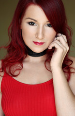 The young redhead woman in red top with black ribbon on the neck