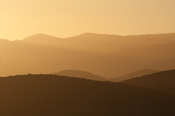 Coucher de soleil sur montagnes cévenoles, contre-jour, or, Cévennes, France