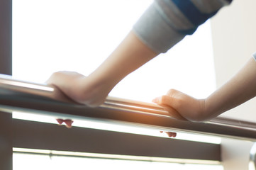 Close up of woman hands holding stainless  rail in a room.