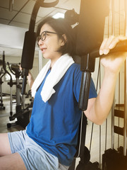 Fototapeta na wymiar Asian woman working out with exercise machine.