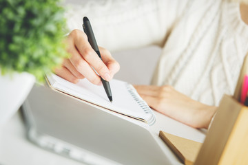Woman writing in spiral notepad