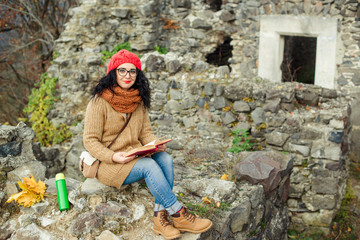 Fototapeta premium Beautiful girl read book near old castle. Autumn time.