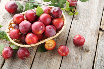 Fresh plums on a grey wooden table