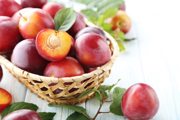 Fresh plums on a white wooden table