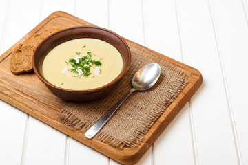 Broccoli cream soup on white wooden table.