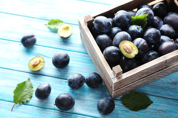 Tasty and ripe plums on blue wooden table