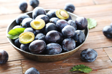 Tasty and ripe plums on brown wooden table
