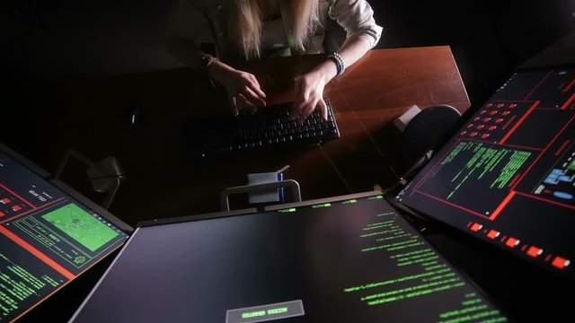 Female hands typing computer code, hacking computer at a dark room. Hacker, programmer at work. HD.