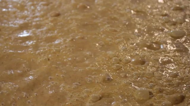 Close up of bubbles from fermenting corn mash in Kentucky bourbon distillery.