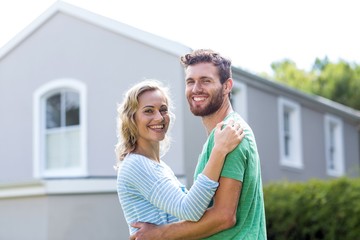 Naklejka premium Couple embracing against house