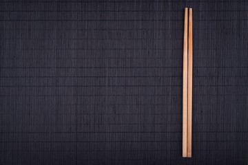chopsticks on black bamboo mat