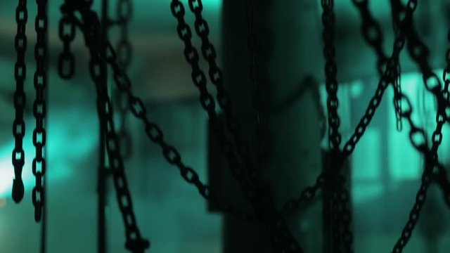 A lot of chins in the location. Room full of chains. Chains in dark space.