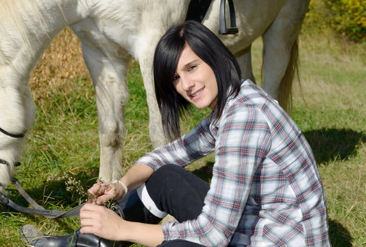 Portrait of a pretty young woman with white horse riding