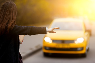 Brunette woman hand gesture catches taxi on the road